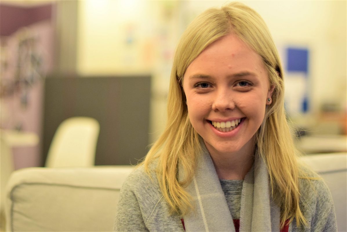 A young woman with long blonde hair smiling.