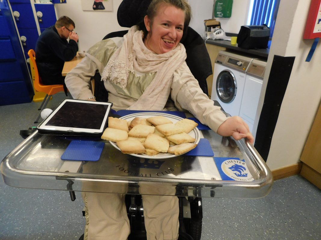 Learner in wheelchair with tray of baked goods