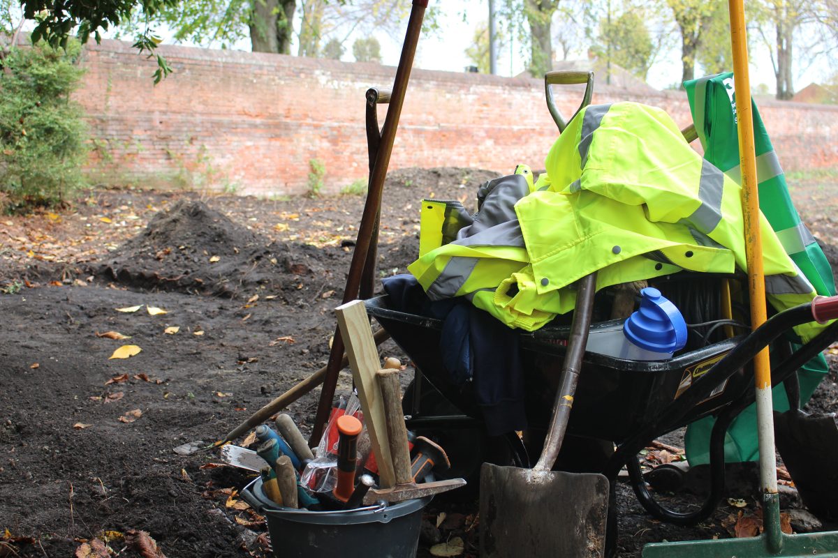 A wheelbarrow full of gardening tools.