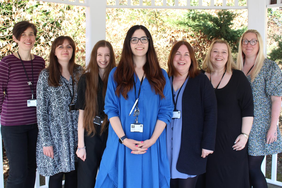 Seven members of the IAGT team standing in a line and smiling at the camera