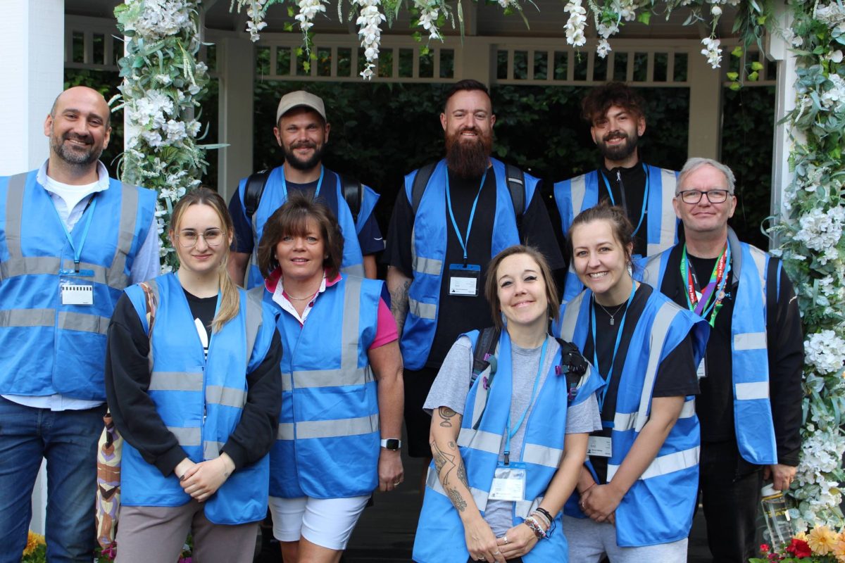 9 Amazon Volunteers wearing blue high vis jackets posing in the pagoda