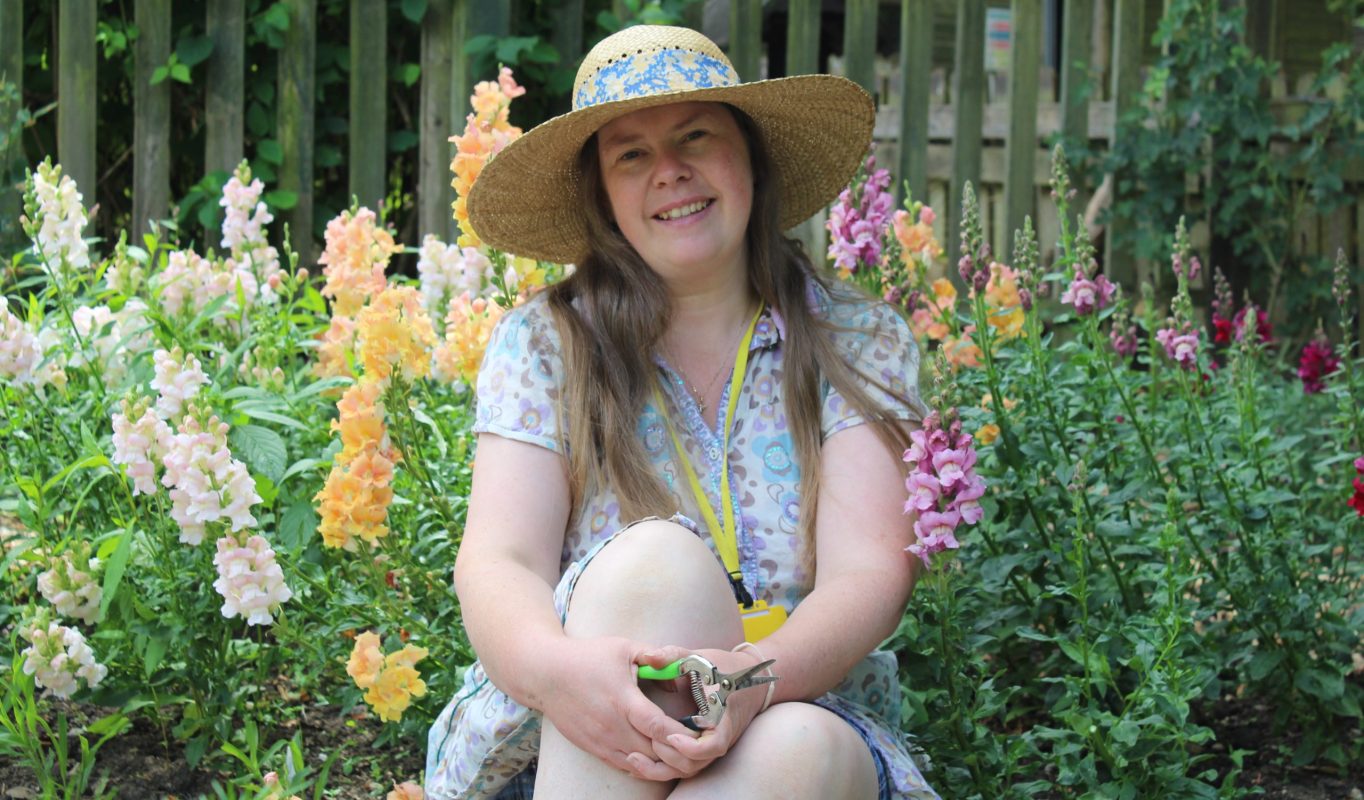 Image of a female volunteer smiling in a garden
