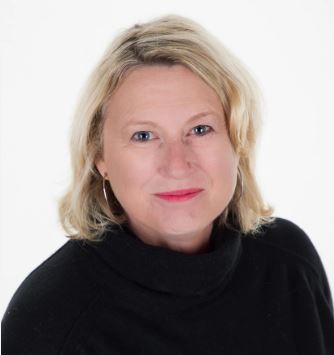 A blonde lady in a black turtle neck jumper wearing pink lipstick