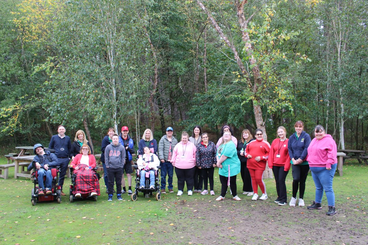 A group of people from Portland Day Service, some in powered wheelchairs, some standing.