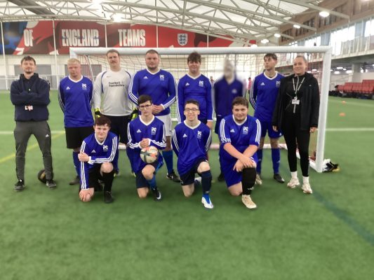 Portland football team line up with staff who supported them.