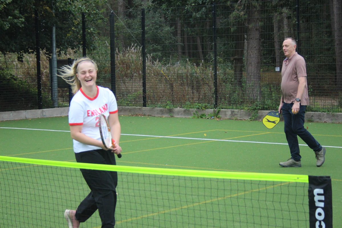 Female learner and male mentor playing tennis