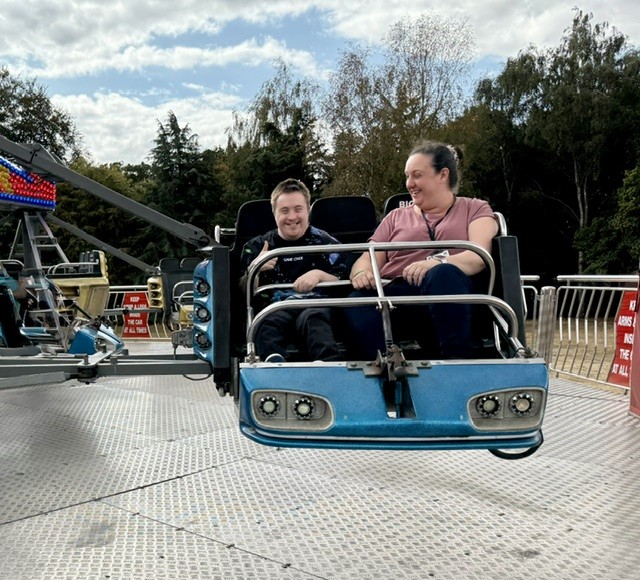 Citizen and staff member on a blue fun fair ride