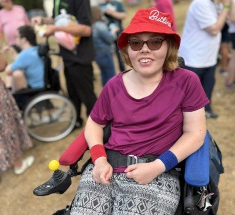 Female citizen wearing a purple top smiling in a crowd of people